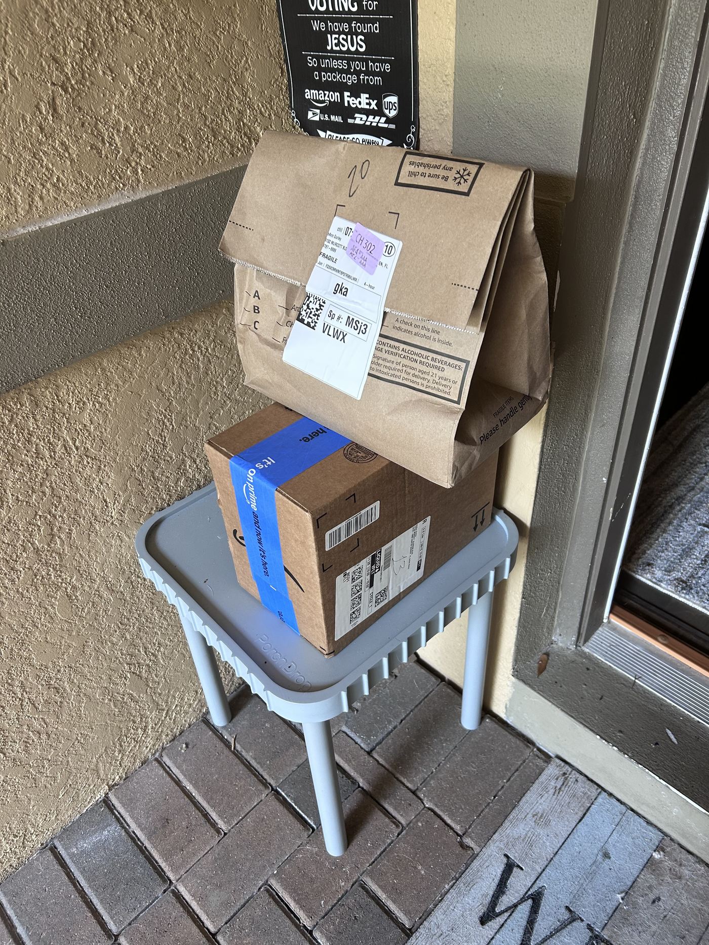 A delivery bag and package resting on the PorchDrop table instead of the porch floor